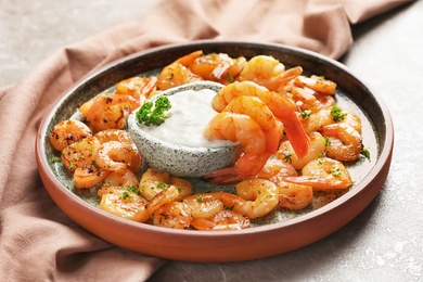 Photo of Plate with fried shrimps and sauce on grey background