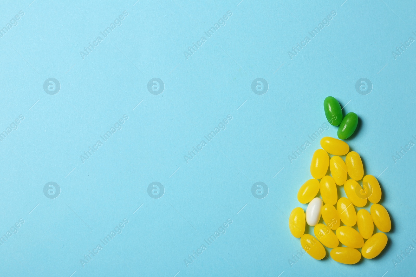 Photo of Bright jelly candies arranged as pear on color background, flat lay. Space for text