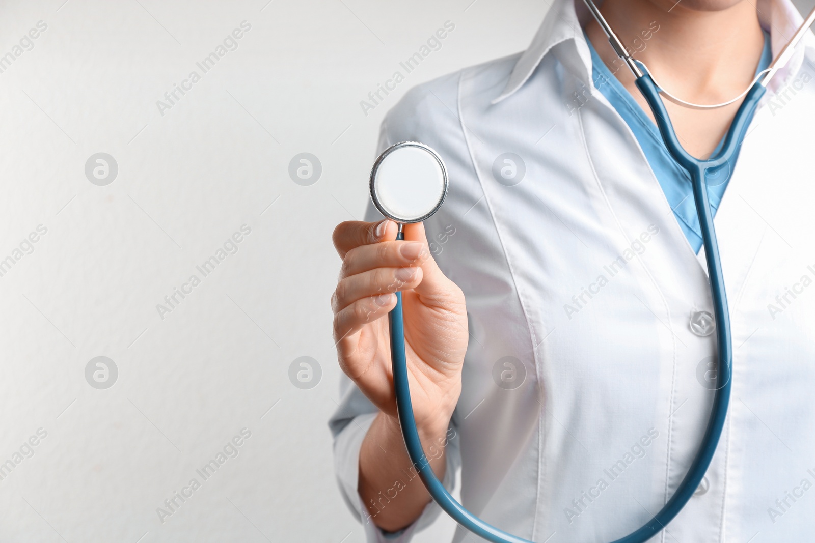 Photo of Doctor with stethoscope on white background, closeup. Medical service