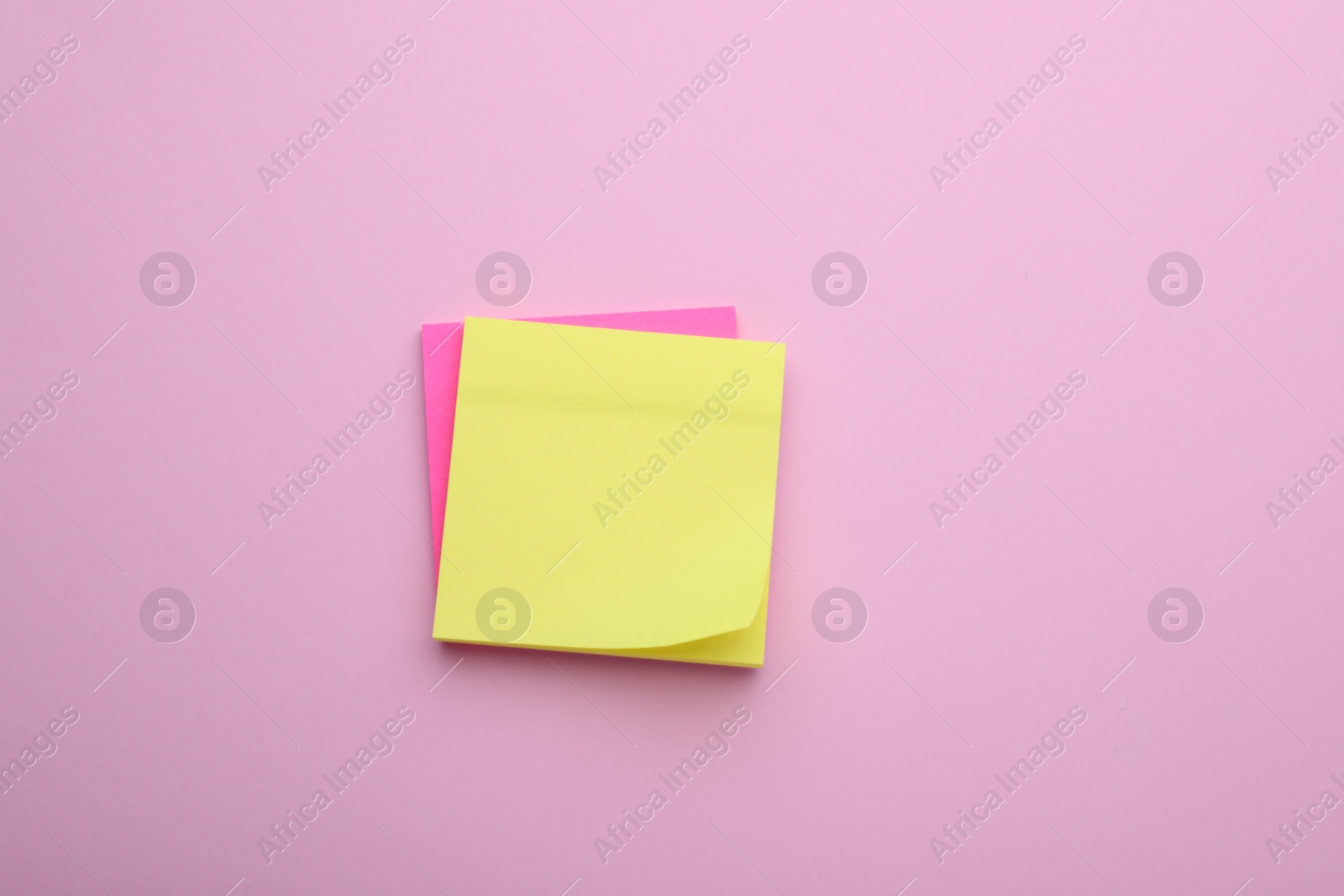 Photo of Paper notes on pale pink background, top view