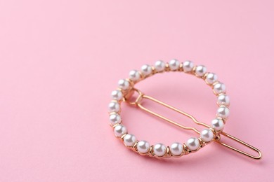Photo of Elegant pearl hair clip on pink background. Space for text