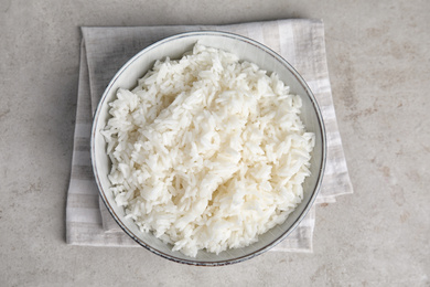 Photo of Bowl with tasty cooked rice on light grey table, flat lay