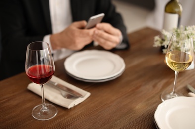 Photo of Man with glass of wine at table in restaurant