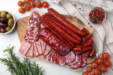 Photo of Flat lay composition with different types of delicious sausages and ingredients on light grey table