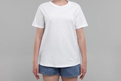 Woman in white t-shirt on grey background, closeup