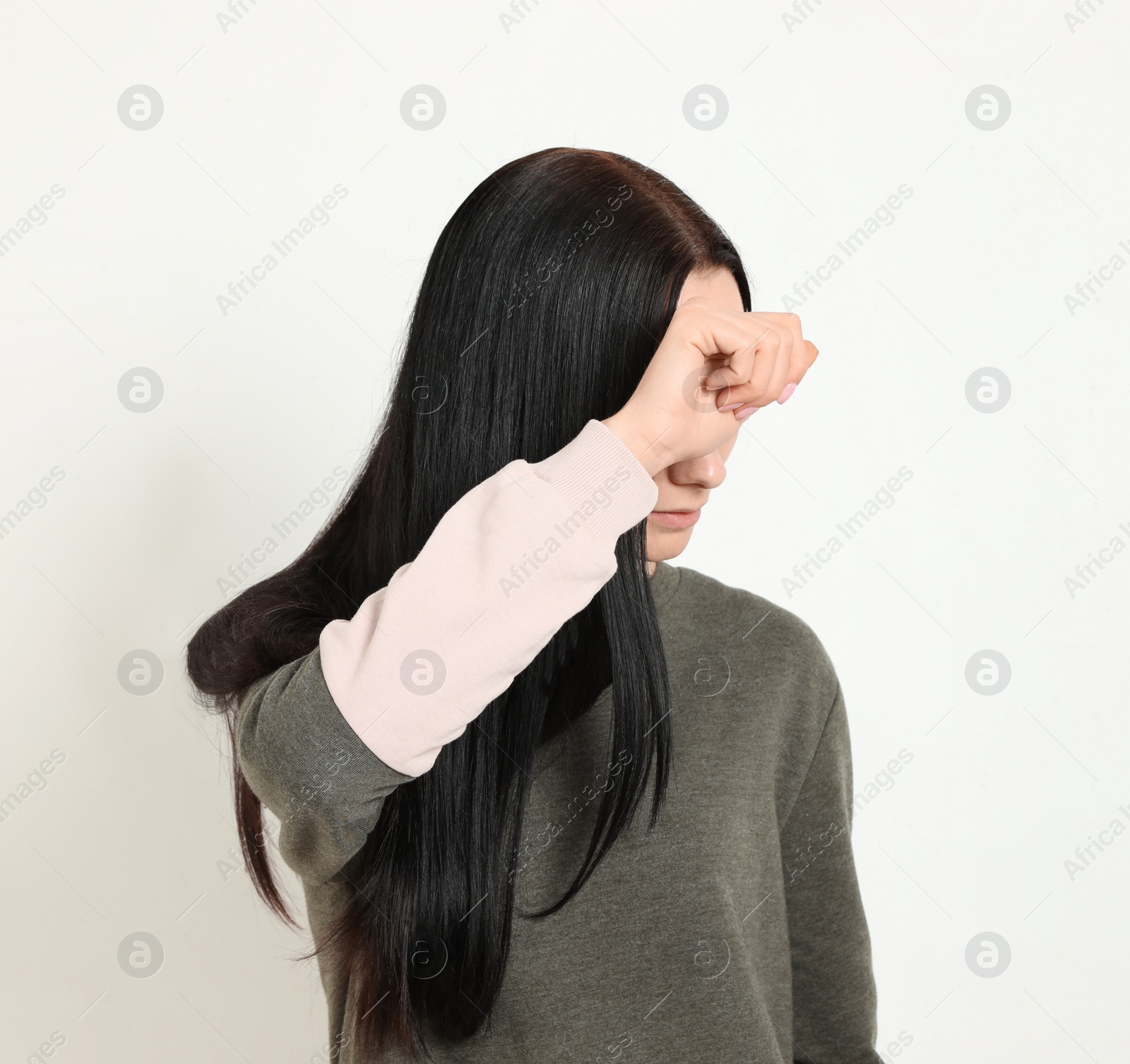 Photo of Young woman covering face against white background. Space for text