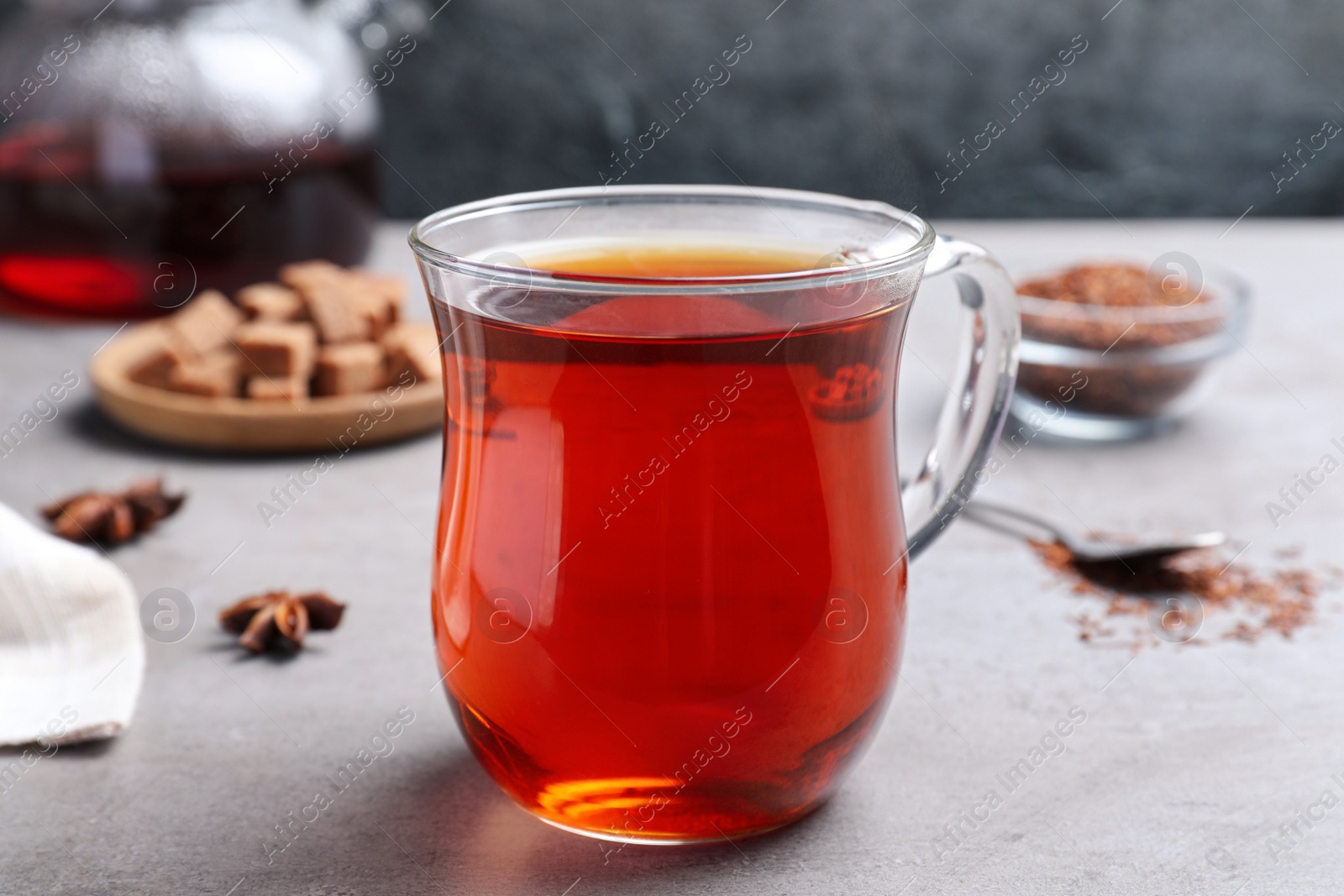 Photo of Freshly brewed rooibos tea on grey table