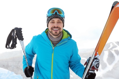 Man with ski equipment spending winter vacation in mountains