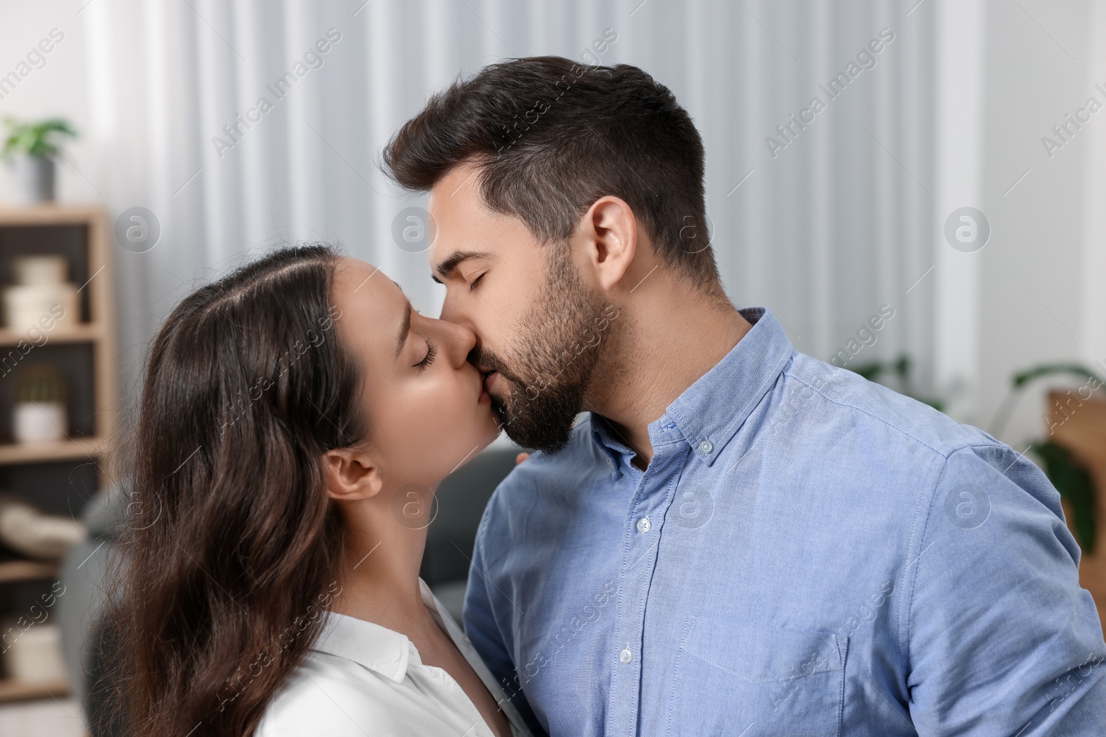 Photo of Love relationship. Passionate young couple kissing at home
