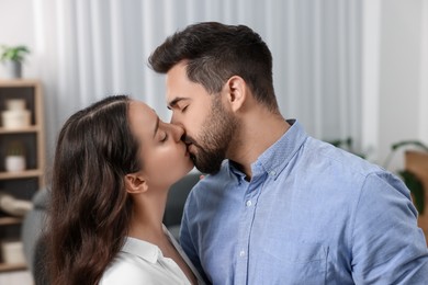 Photo of Love relationship. Passionate young couple kissing at home