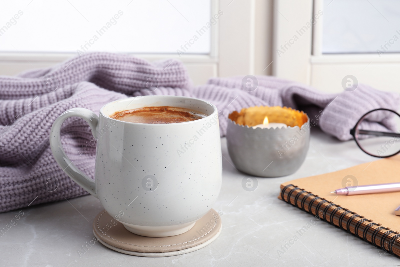 Photo of Composition with cup of hot chocolate and notebook on windowsill. Winter drink