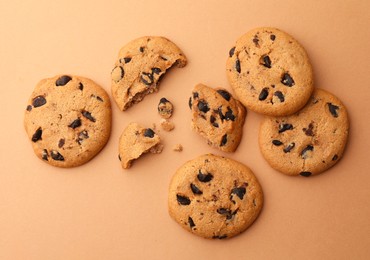 Photo of Delicious chocolate chip cookies on beige background, flat lay