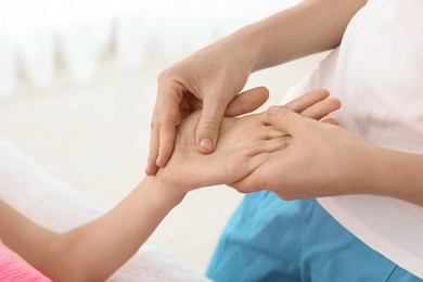 Woman receiving hand massage in wellness center, closeup