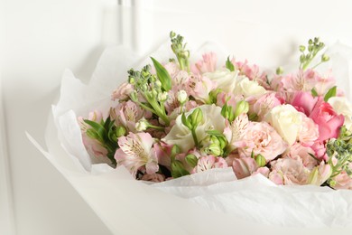 Photo of Beautiful bouquet of fresh flowers near white wall, closeup