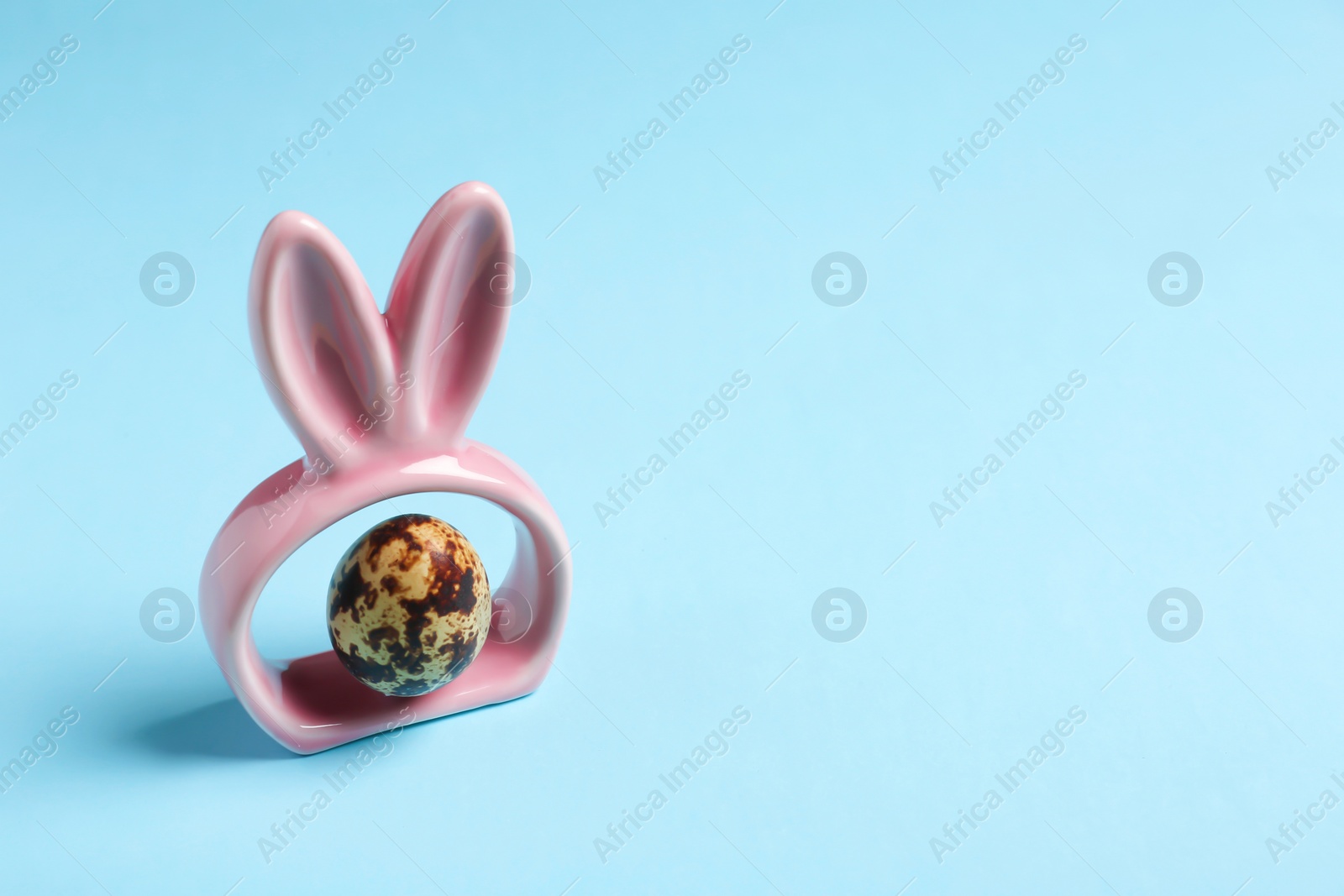 Photo of Easter bunny ears and egg on color background, space for text