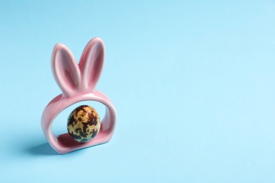 Photo of Easter bunny ears and egg on color background, space for text