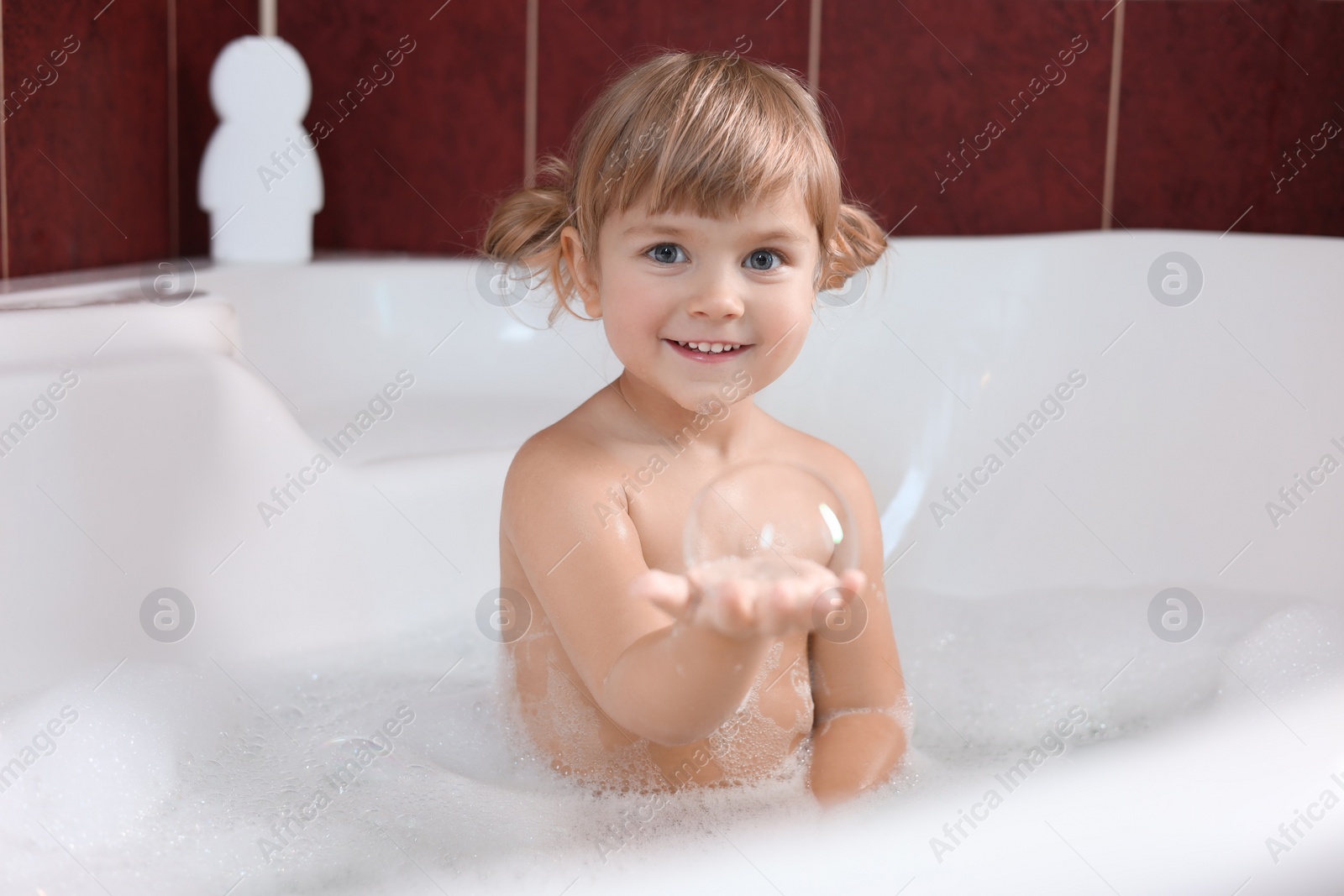 Photo of Happy girl having fun in bathtub at home