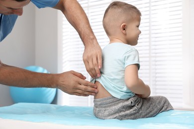 Photo of Orthopedist examining child's back in clinic, closeup. Scoliosis treatment