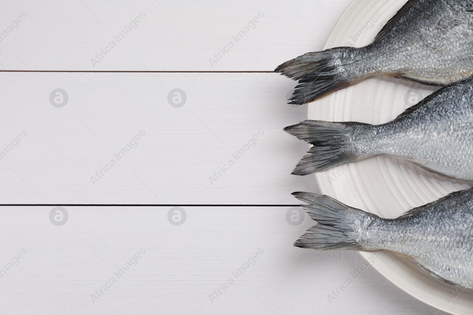 Photo of Fresh raw dorado fish on white wooden table, top view. Space for text