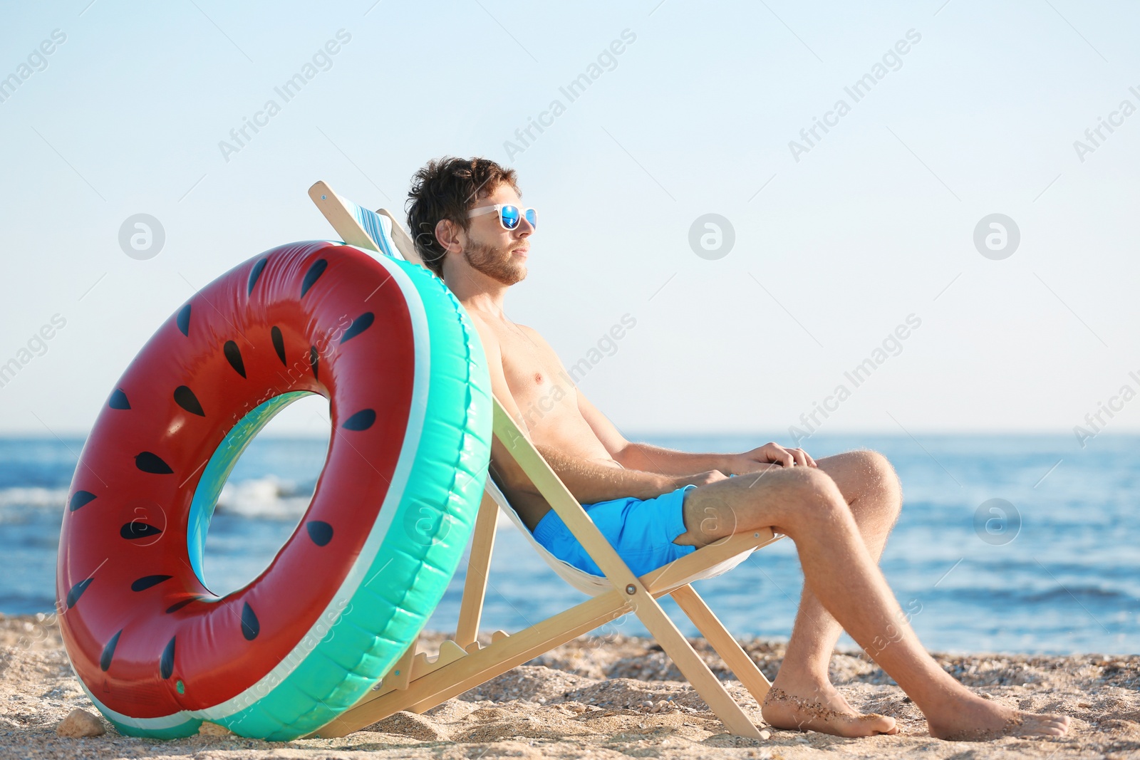 Photo of Young man in beach chair at seacoast