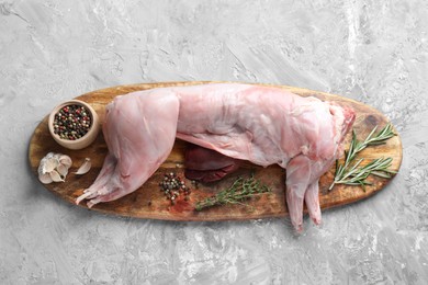 Whole raw rabbit, liver and spices on grey textured table, top view