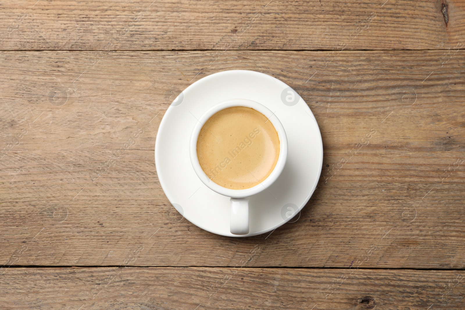 Photo of Aromatic coffee in cup on wooden table, top view