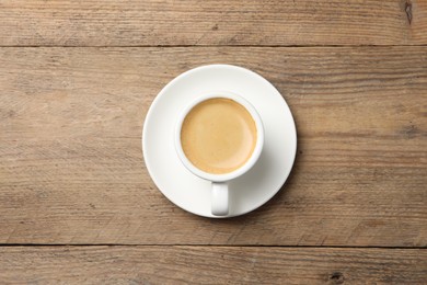 Aromatic coffee in cup on wooden table, top view