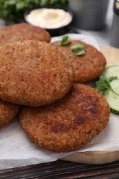 Tasty vegan cutlets served on wooden table, closeup