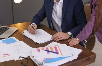 Businessman and assistant working with documents at table, closeup