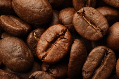 Photo of Pile of roasted coffee beans as background, closeup