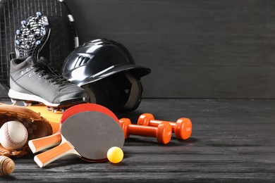 Photo of Many different sports equipment on dark grey wooden table, space for text