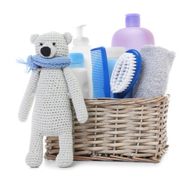 Wicker basket with baby cosmetic products and knitted bear isolated on white