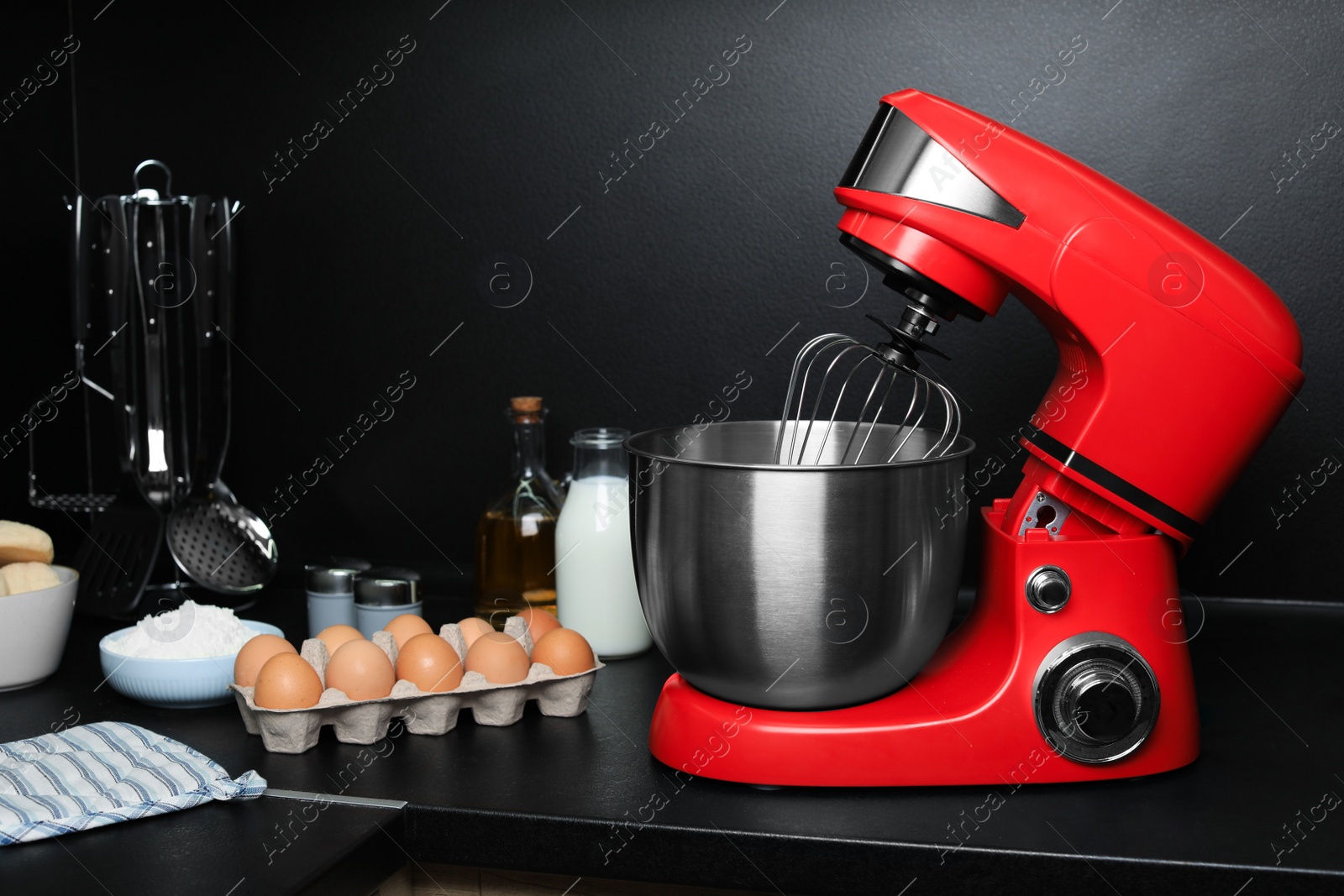 Photo of Modern stand mixer and ingredients on countertop in kitchen. Home appliance