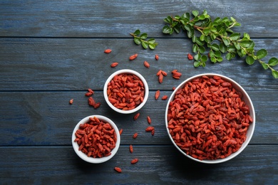 Flat lay composition with dried goji berries on blue wooden table. Healthy superfood