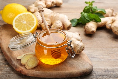 Photo of Ginger, honey and lemon on wooden table, space for text. Natural cold remedies