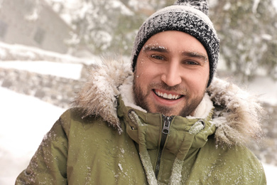 Happy young man outdoors on snowy winter day