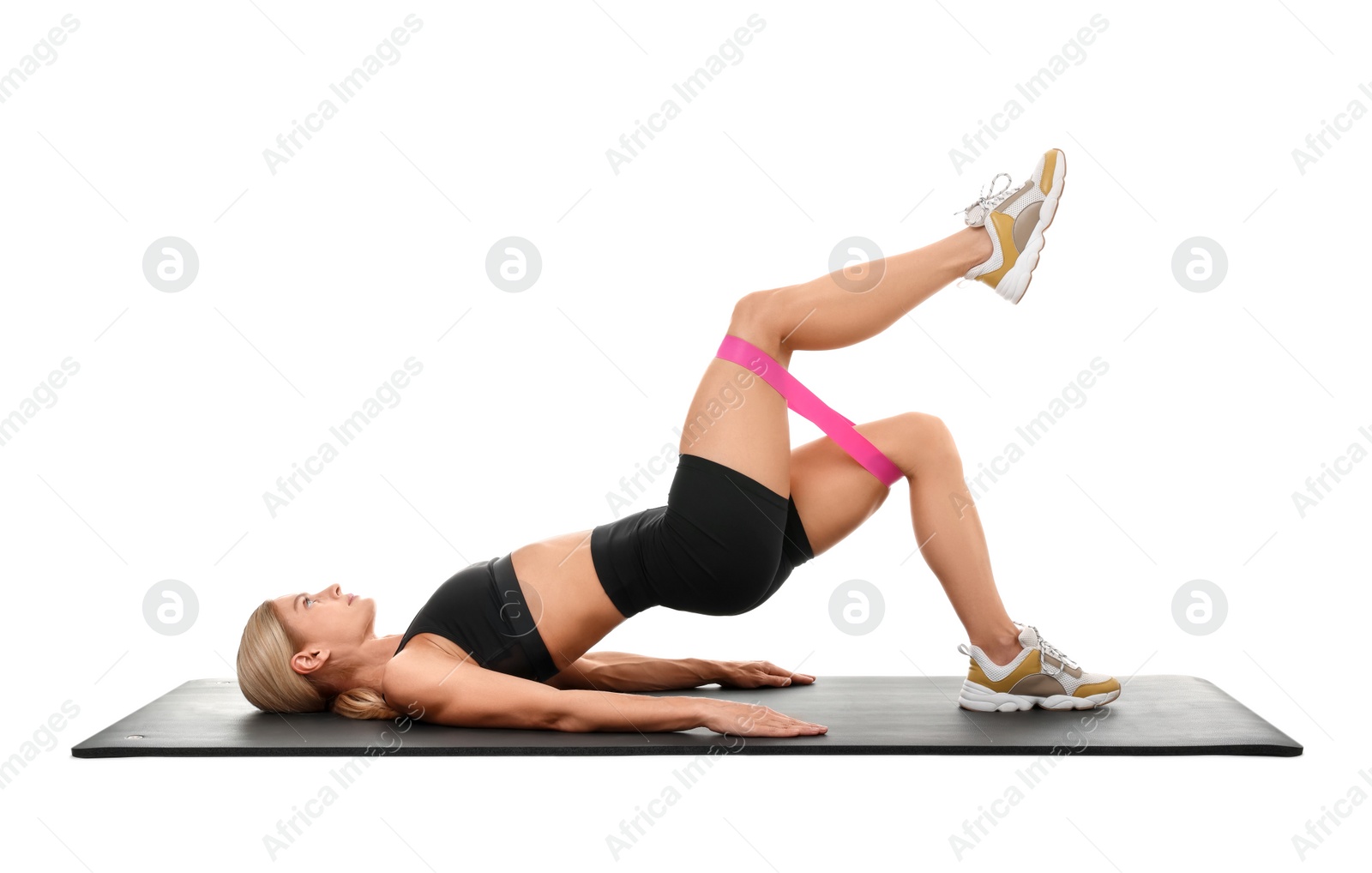 Photo of Woman exercising with elastic resistance band on fitness mat against white background