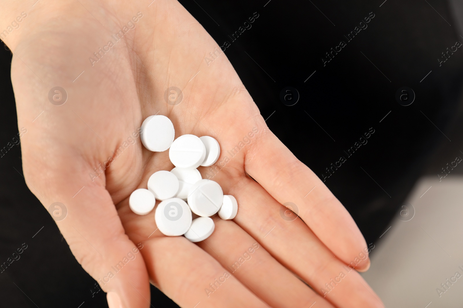Photo of Woman holding many pills in hand, closeup view