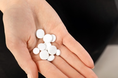 Woman holding many pills in hand, closeup view