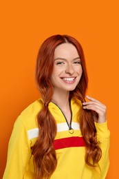 Portrait of smiling beautiful woman on orange background