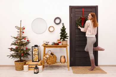 Photo of Woman decorating her entry way for Christmas
