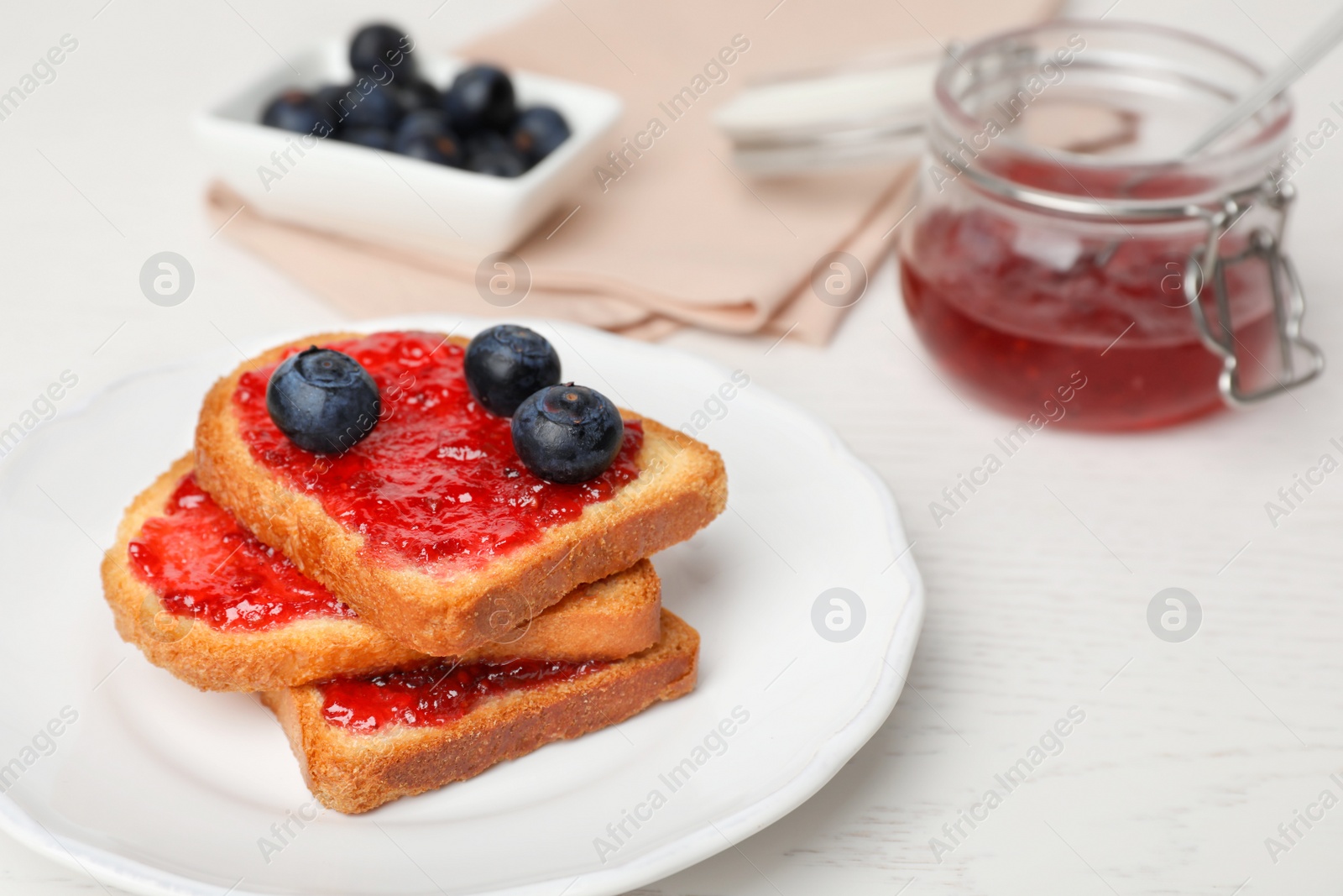 Photo of Toasts with jam and berries on plate, closeup