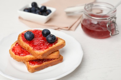 Photo of Toasts with jam and berries on plate, closeup