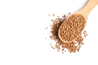 Spoon with uncooked buckwheat on white background, top view