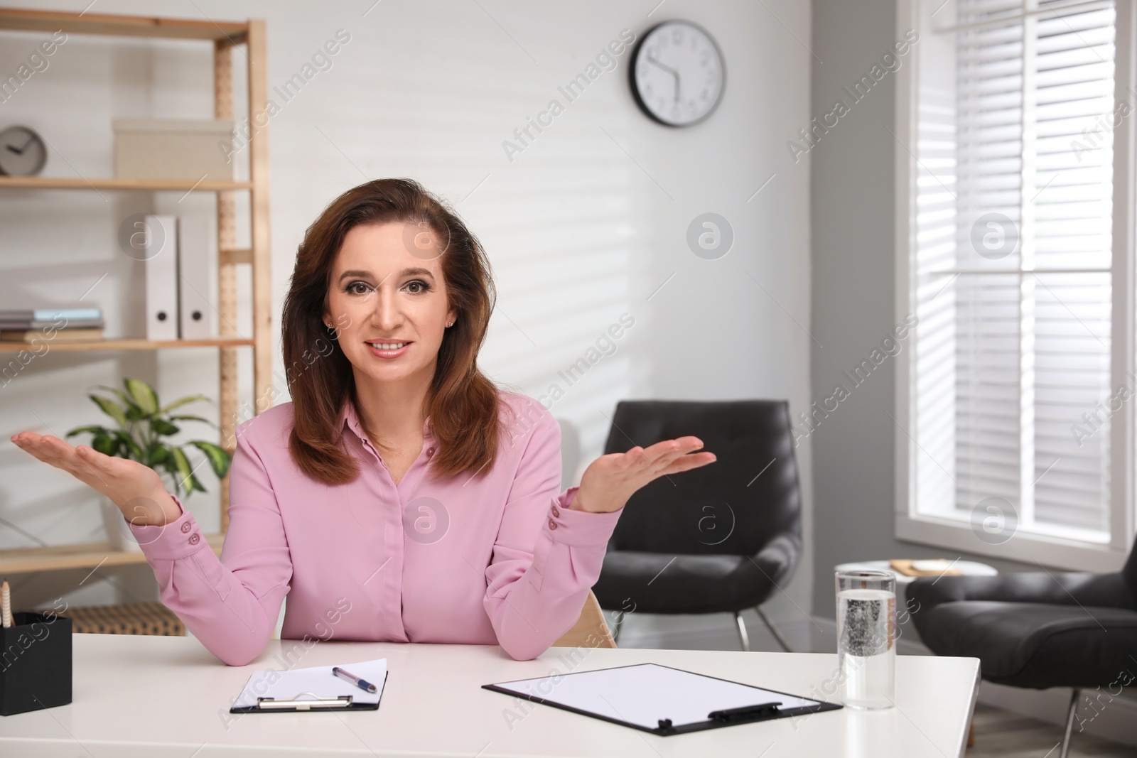 Photo of Portrait of psychotherapist at white table in office