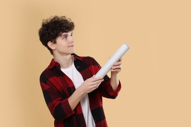 Photo of Teenage boy with party popper on light brown background. Space for text