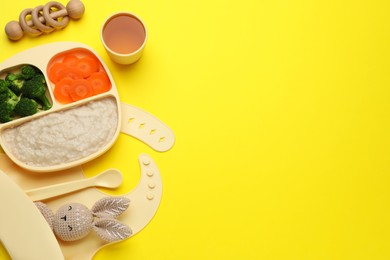 Photo of Healthy baby food in plate and accessories on yellow background, flat lay. Space for text