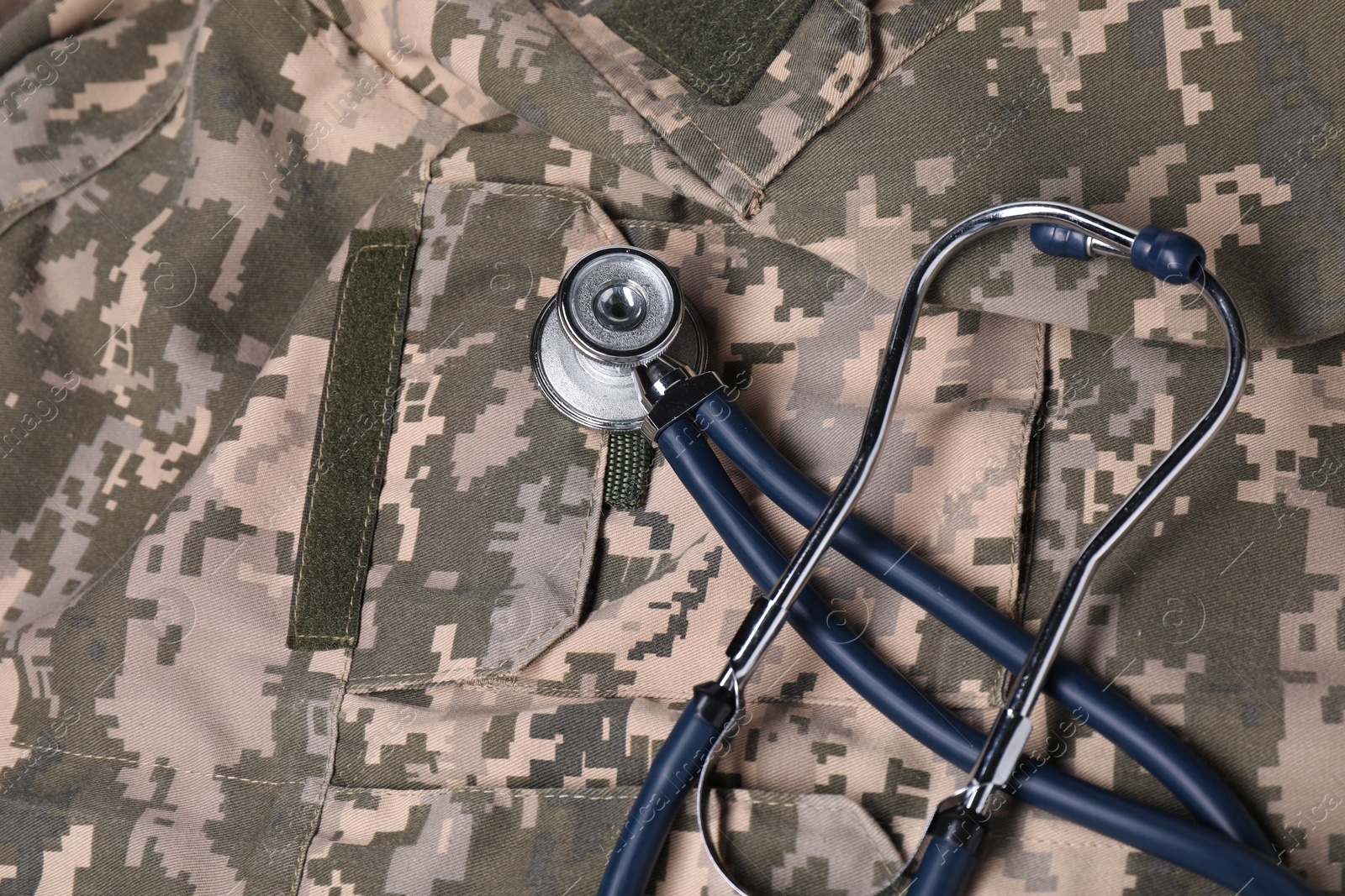 Photo of Stethoscope on soldier uniform, top view. Military service