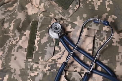 Photo of Stethoscope on soldier uniform, top view. Military service