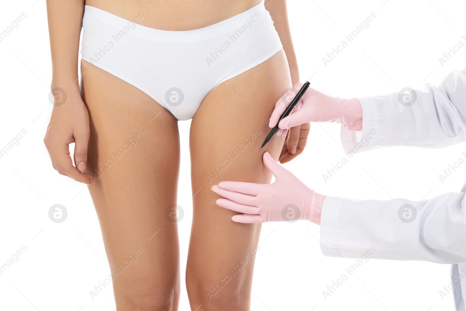 Photo of Doctor drawing marks on woman's body against white background, closeup. Plastic surgery